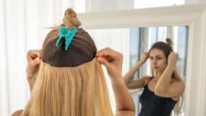 Woman adding hair extensions on her hair